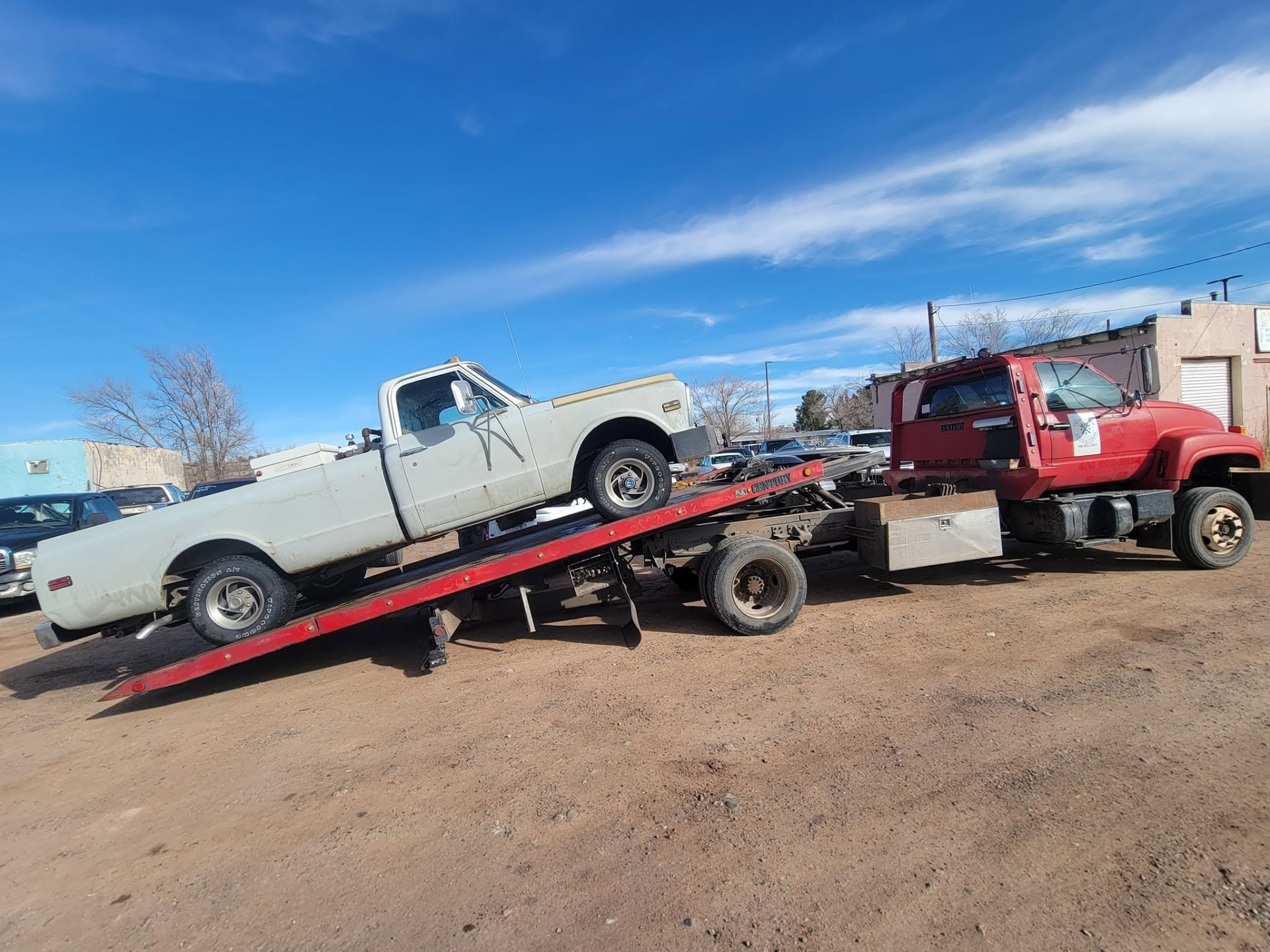 K&P Towing & Recovery flatbed tow truck assisting a stranded vehicle on an Arizona desert highway