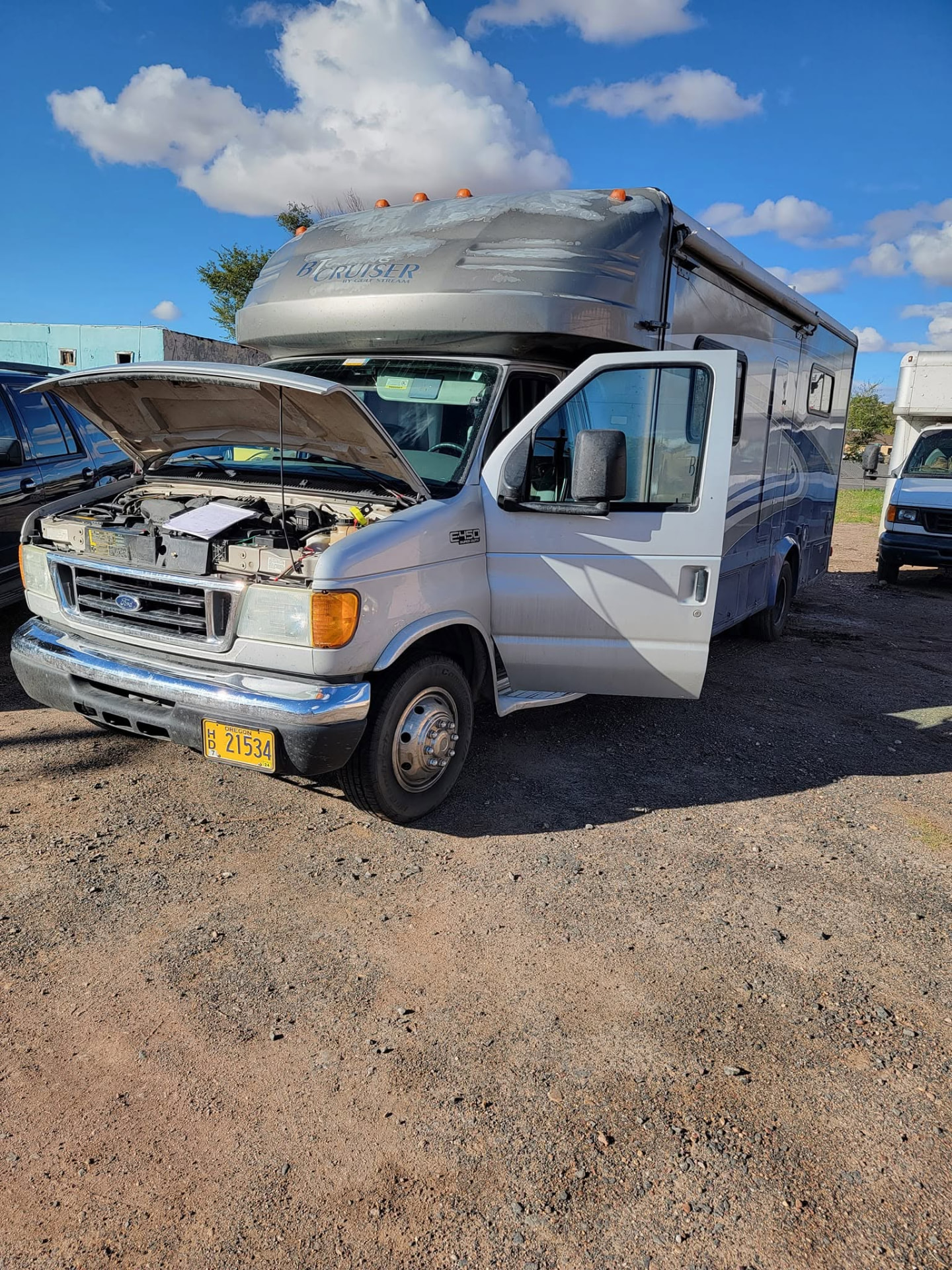 Class C motorhome with the hood up for repairs at the K&P yard